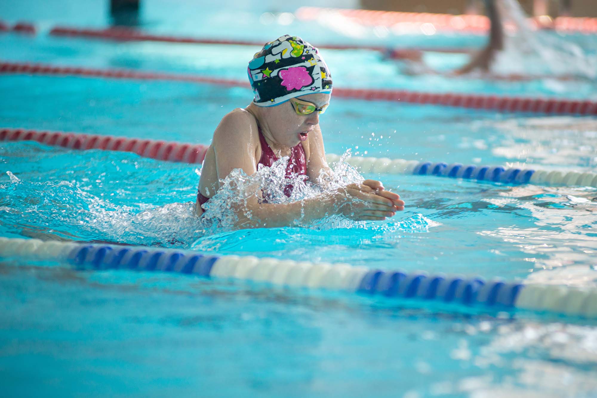 Swimmer child swims breaststroke swimming style in the pool